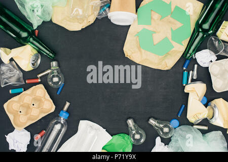 frame of various types of trash with recycle sign on black Stock Photo