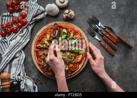 top view of slicing pizza with circle cutter on concrete table Stock Photo