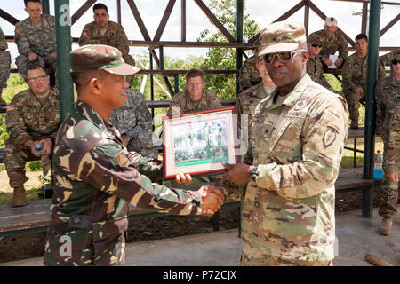 Philippine Army Lt. Col. Virgilio Noora presents U.S. Army Brig. Gen. Stephen Michael with a commemorative photo during a site visit in support of Balikatan 2017 at Camp Dela Cruz in Upi, Gamu, Isabela, May 11, 2017. Noora is the chief of the 41st Infantry Battalion and Michael is the deputy commanding general of the 25th Infantry Division. Balikatan is an annual U.S.-Philippine bilateral military exercise focused on a variety of missions, including humanitarian assistance and disaster relief, counterterrorism and other combined military operations. Stock Photo