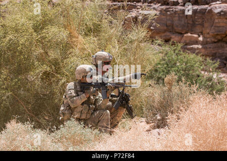 Cpl. Lawrence Butts, an infantryman from Phil Campbell, Alabama, points out sectors of fire for Spc. Ian Lathon, an infantryman from San Bernadino, California, both assigned to Headquarters and Headquarters Company, 3rd Battalion, 8th Cavalry Regiment, 3rd Armored Brigade Combat Team, 1st Cavalry Division, at a squad live-fire exercise May 11 in Wadi Shadiya, Jordan as part of Exercise Eager Lion 2017. Eager Lion was a two-week-long multinational exercise with the Hashemite Kingdom of Jordan, in order to exchange military expertise and improve interoperability among partner nations. Stock Photo