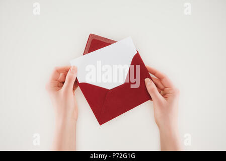 cropped shot of woman opening red envelope with blank paper isolated on white Stock Photo