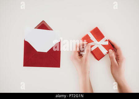 cropped shot of woman opening gift box with red envelope isolated on white Stock Photo