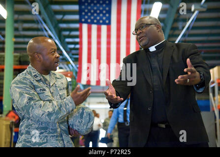 Chaplain (Capt.) Kevin Pugh, 436th Airlift Wing, talks with Reverend Darryl Scott, Philadelphia Police Department Police Clergy, Philadelphia, Pa., while visiting the 436th Security Forces Squadron Ravens section May 11, 2017, at Dover Air Force Base, Del. Fifteen members of the police department toured different sections of the 436th SFS during their five-hour visit to the base. Stock Photo