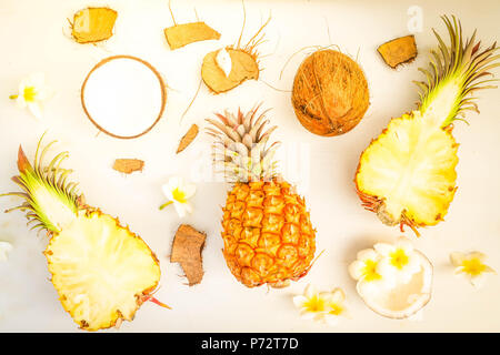 Summer flat lay scene with tropical fruits pineapples and coconuts on gray wooden , toned Stock Photo