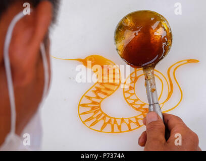 China. 4th July, 2018. A folk artist makes snake shaped sugar painting in Xi'an, northwest China's Shaanxi Province. Credit: SIPA Asia/ZUMA Wire/Alamy Live News Stock Photo