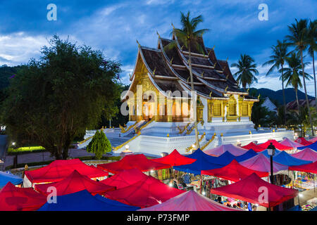 LUANG PRABANG, LAOS - 28 JUNE 2018 - Royal Palace in Luang Prabang, Laos stands beautifully against late evening blue sky and night market on June 28, Stock Photo