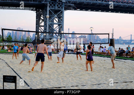 Asian people playing beach volleyball at Domino Park in Williamsburg, Brooklyn, New York City. Stock Photo