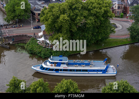 A tour boat sails through the Wester Stadsgracht in the city center of Leeuwarden, the Netherlands 2018. Stock Photo