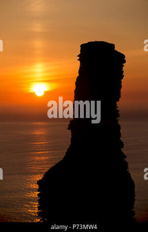 A man silhouetted against the setting sun on the beach at Thong Sala ...