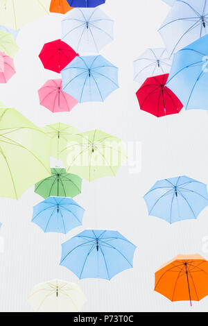 Looking up the multiple umbrellas in various colors against white background. Stock Photo