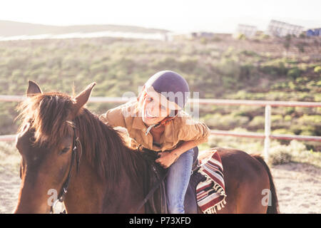 ride with a helmet for a beautiful attractive young woman with nice smile. jeans and casual clothes for outdoor girls in leisure activity with brown h Stock Photo