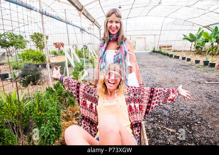 couple of beautiful young woman having fun together in nature biologic place cartying to play. open arms for joyful and happiness concept with big smi Stock Photo