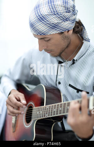 Young man in bandana playing the guitar Stock Photo