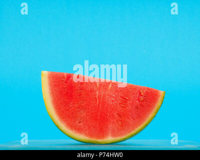 Slice of a watermelon on a blue background, summer food or healthy eating concept Stock Photo