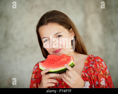 Beautiful young girl eats watermelon on isolated background Stock Photo