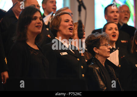 ANNANDALE, VIRGINIA  (October 30, 2016) Petty Officer 1st Class Kristen Pagent, center, performs with the U.S. Navy Band Sea Chanters chorus during their 60th anniversary concert. The Sea Chanters chorus celebrated their 60th anniversary iin Annandale, Virginia, with a concert featuring alumni from the group. The chorus was formed as an all-male group in 1956 and tasked with perpetuating the songs of the sea. In 1980, the group added women to their ranks and expanded their repertoire to include everything from Brahms to Broadway. Stock Photo