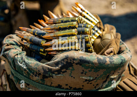 U.S. Marines stage a belt of 7.62 ammunition inside of a kevlar during a squad live-fire range aboard Babadag Training Area, Romania, June 6, 2018. Black Sea Rotational Force Marines conduct live-fire ranges to increase readiness to respond to any situation, Marines train to employ their weapon systems effectively and traverse any terrain in order to build proficiency and confidence when rapidly moving and engaging targets. (U.S. Marine Corps Photo by Cpl. Alexander Sturdivant/Released) Stock Photo