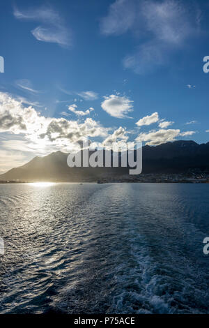 Leaving Ushuaia on an expedition cruise ship with passing clouds over the mountain range, Argentina Stock Photo