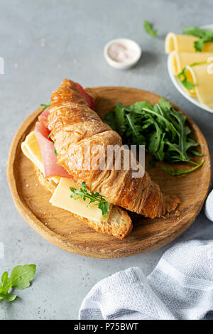 Tasty croissant sandwich with ham and cheese on concrete background. Top view. Breakfast sandwich Stock Photo