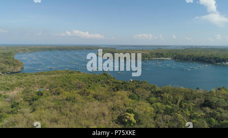 Fish farm with cages for fish and shrimp in the Philippines, Luzon. Aerial view of fish ponds for bangus, milkfish. Fish cage for tilapia, milkfish farming aquaculture or pisciculture practices. Stock Photo