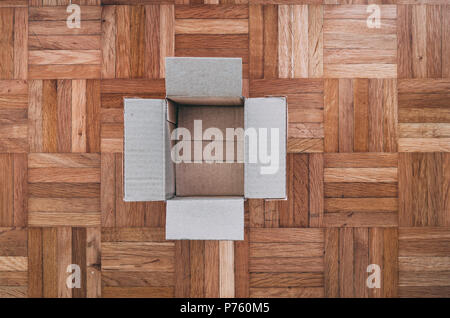 Empthy cartboard box on a wooden tile floor, top view Stock Photo