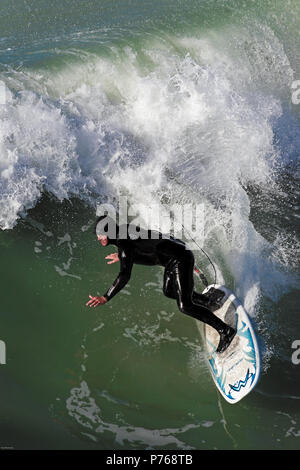 Surfing in winter at New Brighton beach, Christchurch, New Zealand Stock Photo