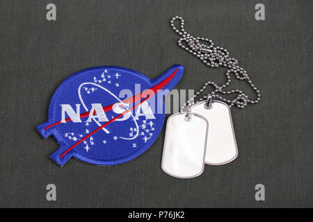 15 March 2018 - The National Aeronautics and Space Administration (NASA) emblem patch and dog tags on green uniform background Stock Photo