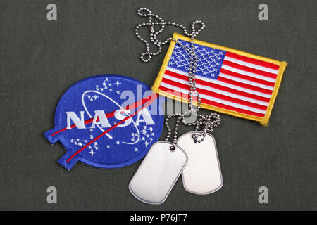 15 March 2018 - The National Aeronautics and Space Administration (NASA) emblem patch, dog tags, and US Flag patch on green uniform background Stock Photo