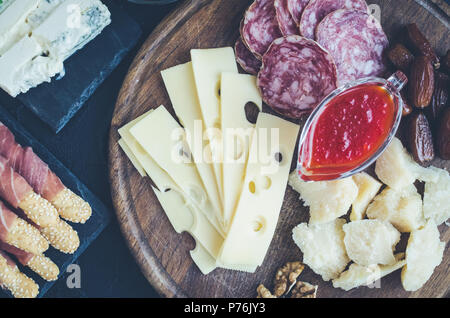 Table full of mediterranean appetizers, tapas or antipasto. Assorted Italian food set. Delicious snack on party or picnic time. Chopping board with me Stock Photo
