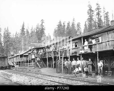 . English: Crew at logging camp no. 3, Schafer Brothers Logging Company, 1922 . English: Caption on image: C.K. Kinsey Photo. No. 447 PH Coll 516.3868 Schafer Brothers Logging Company got its start in 1893 when brothers Peter, Albert and Hubert Schafer began logging on the family homestead 6 miles upstream from the mouth of the Satsop. They logged with oxen and horses for 20 years. The company's first donkey engine was purchased from Washington Iron Works. Hubert went to work at the factory to learn how donkey engines were made and also to have all of his wages, except for living expenses, app Stock Photo