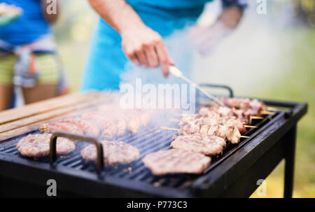 Happy students having barbecue on summer day Stock Photo