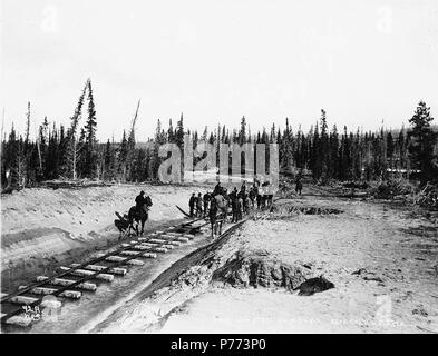 . English: Laying track near camp 6 at White Pass summit for the White Pass & Yukon Railroad, Alaska, ca. 1898. English: Caption on image: 'Spiking down steel on W.P. & Y. R. near camp 6, Alaska.' Original image in Hegg Album 3, page 42 . Original photograph by Eric A. Hegg 753; copied by Webster and Stevens 42.A. Subjects (LCTGM): Railroad construction & maintenance--Alaska--White Pass; Railroad tracks--Alaska--White Pass; Railroad construction workers--Alaska--White Pass; Horses--Alaska--White Pass Subjects (LCSH): White Pass (B.C.); Mountain passes--Alaska; White Pass & Yukon Route (Firm)   Stock Photo