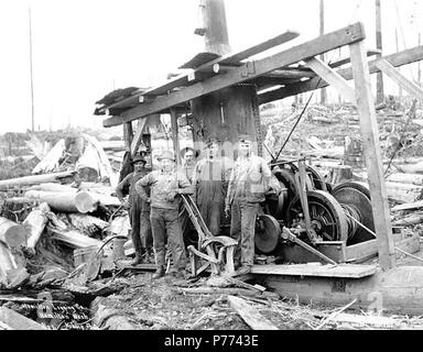 . English: Logging crew and donkey engine, Hamilton Logging Company, ca. 1912 . English: Caption on image: Hamilton Logging Co., Hamilton, Wash. Kinsey Photo. No. 4 PH Coll 516.1445 The English Lumber Company had a controlling interest in the Hamilton Logging Company, which did business under that name from ca. 1908 to 1917, when the name was changed to the Lyman Timber Company. Hamilton is a community on the north bank of the Skagit River ten miles east of Sedro Woolley in central Skagit County. It was once boomed as The Pittsburgh of the West because of iron and coal deposits in the vicinity Stock Photo