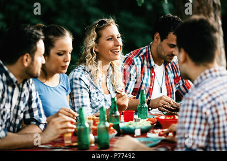 Group of happy people eating food outdoors Stock Photo