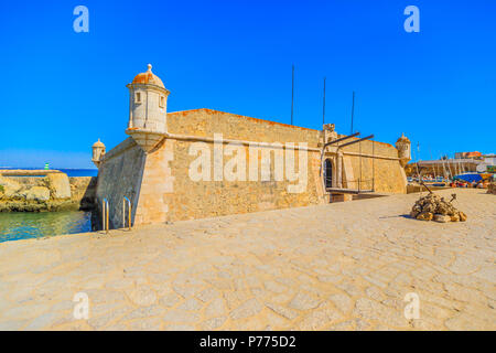Fort of Ponta da Bandeira, a military architecture at entrance of the harbor in Lagos, Algarve, Portugal. The fortress is near Praia do Cais da Solaria. Blue sky with copy space Stock Photo