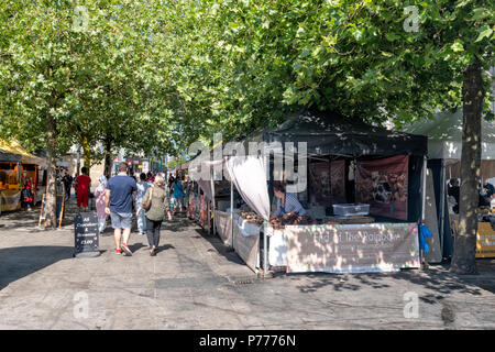 People milling around various food stalls in an open air market near Piccadilly Gardens in Manchester City Centre, UK Stock Photo