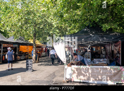 People milling around various food stalls in an open air market near Piccadilly Gardens in Manchester City Centre, UK Stock Photo