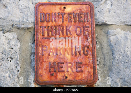 “Don’t even think of parking here”. Humorous No Parking message on a rusty textured old metal sign. Isle of Portland, Dorset, England, United Kingdom. Stock Photo