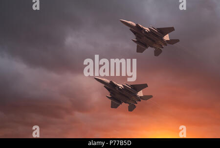 US Air Force McDonnell Douglas, two USAF low flying F-15E Strike Eagles at sunset. High speed low flying fighter jet, with a beautiful orange glowing  Stock Photo