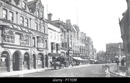 English: Market Place, Reading, looking south-eastwards to High Street, c. 1890. On the east side, Nos. 20 and 21 (Market Place Chambers, with signs for Butler and Company, auctioneers, valuers and surveyors, and for Arthur Ayres, auctioneer and estate agent); Nos. 19 and 18 (Elephant Hotel); No. 17 (Frank Cooksey, estate agent); Nos. 16, 15, 14 and 13 (London and County Bank); Nos. 12 and 11 (Morris and Davis, tailors); Nos. 10, 9 and 8 (Sutton and Sons, Royal Seed Establishment); No. 7 ('Reading Mercury' office). On the south side, No. 52 (Hill and Company, rubber merchants). A horse-bus wai Stock Photo