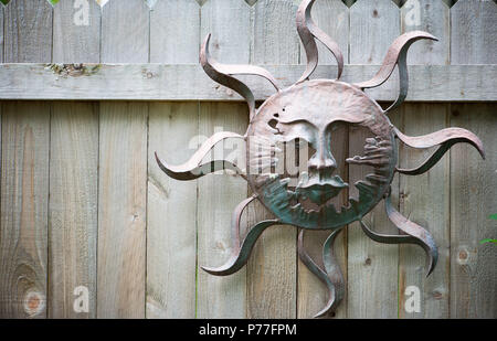 Wooden fence with abstract sun made from tin Stock Photo