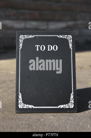 To do list - chalkboard on the street in the sunset with space for own text. Stock Photo