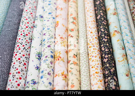 fabric rolls with floral pattern on textile market - Stock Photo