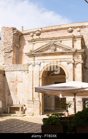 Italy Sicily medieval walled town Erice on Monte San Giuliana cult Venus Erycina Piazza S Domenico St Square crucifix stone bench parasol cafe Stock Photo