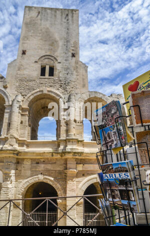 Arles, France - June 16th, 2018: Tourists pass souvenir shops next to the Arenes d'Arles, Roman Amphitheater Stock Photo