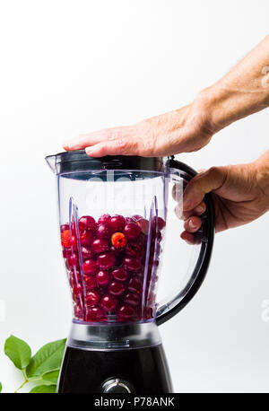 https://l450v.alamy.com/450v/p78ank/person-making-cherry-smoothie-with-a-blender-isolated-p78ank.jpg