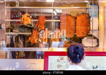London, UK - June 22, 2018 - A tourist is reading the menu outside Four Seasons restaurant, famous for the crispy duck, in London Chinatown Stock Photo