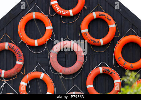 A collection of lifesavers on the side of the wall Stock Photo