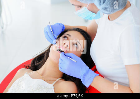 Young beautiful girl in dental office. Children's dentist examines teeth to a child. Stock Photo
