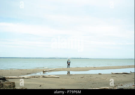 young bearded man, dressed in youth clothes, travels by the sea, adventures on a warm summer day. Stock Photo